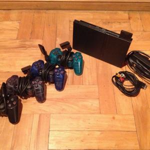 PlayStation 2 con controles y juegos varios