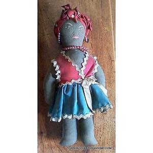 antigua muñeca de trapo con cara bordada y ropa de hule de