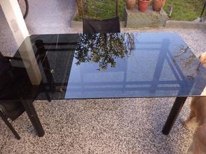 mesa de vidrio con estructura de metal negro con vidrio fume