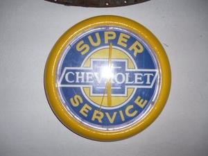 "Carteles enlozados, escudos antiguos y reloj de Chevrolet"