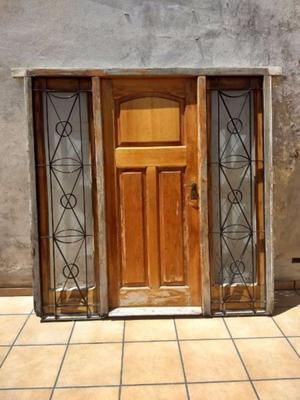 Puerta de madera con puertas laterales vidriadas y con rejas