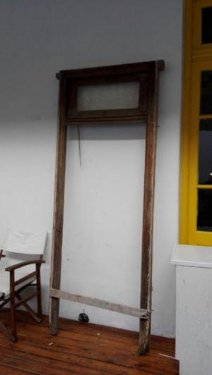 Puerta antigua de madera: una hoja y banderola con marco de