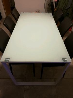 Mesa rectangular de vidrio con 6 sillas forradas en cuero