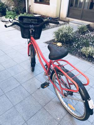 Bicicleta roja con pie para apoyar y canasto incluido
