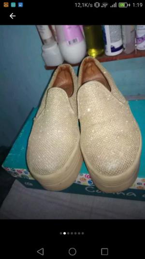 Panchas doradas brillosas de cuero