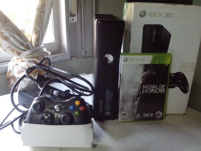 Xbox 360 slim, con un joystick y un juego original.