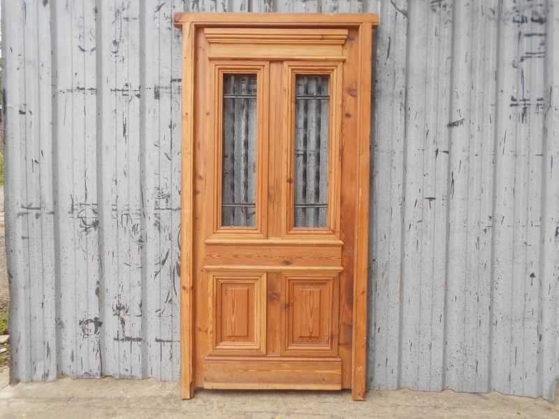 Puerta de frente en madera antigua de pinotea con rejas