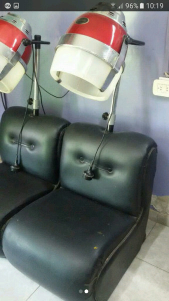 Sillones de peluquería con secadores de pelo