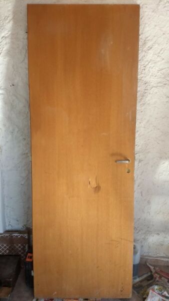 Puerta placa de madera sin marco con un golpe