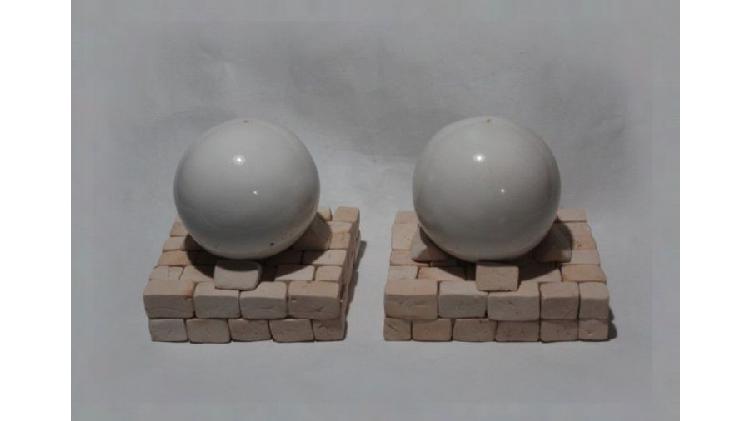 2 esferas blancas esmaltadas en bases de ladrillo altas