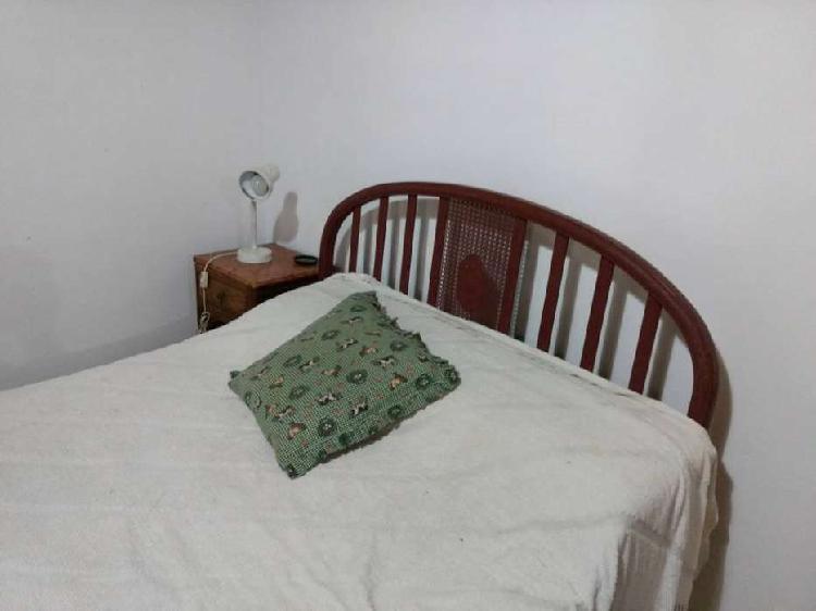 Cama doble de hierro antigua con colchón y mesa de luz